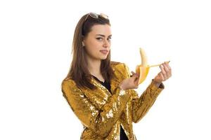 schattig elegant vrouw in gouden jasje met banaan foto