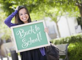 gemengd ras vrouw leerling Holding schoolbord met terug naar school- foto