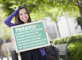 gemengd ras vrouw leerling Holding schoolbord met theorie en definitie foto