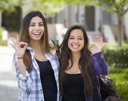 gemengd ras vrouw studenten Aan school- campus met Oke teken foto