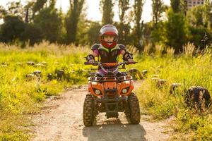 weinig meisje rijden atv quad fiets in ras bijhouden foto