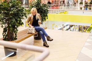 een vrouw rust in een boodschappen doen centrum foto