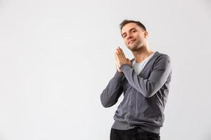 portret emotioneel Mens staand in de buurt een muur Aan een grijs achtergrond foto