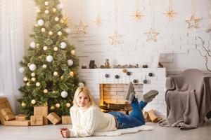 jong vrouw door een haard Aan warm Kerstmis avond foto