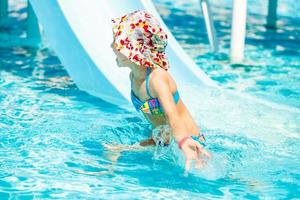 meisje glijden in zwembad gedurende kalkoen vakanties zomer vakantie foto