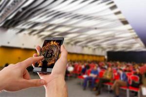 bespotten omhoog beeld van vrouw hand- gebruik makend van mobiel smartphone met blanco wit scherm in vergadering of conferentie kamer wazig achtergrond. bedrijf congres en onderwijs concept. knipsel pad en ruimte foto