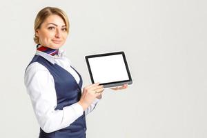 charmant stewardess gekleed in blauw uniform met leeg blanco in handen foto