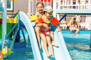 twee weinig kinderen spelen in de zwemmen zwembad foto