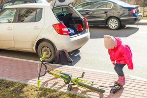 een weinig meisje pompen omhoog een fiets band. foto