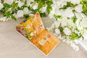 foto album Aan de tafel met roos bloemblaadjes. bruiloft decoraties. feestelijk evenement