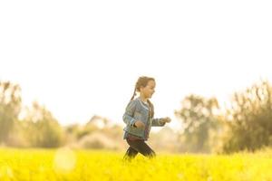 schattig klein meisje op de weide in zomerdag foto