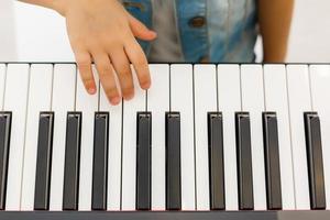 handen van kind Aan piano toetsenbord foto