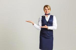 portret van charmant stewardess vervelend in blauw uniform. geïsoleerd Aan wit achtergrond. foto