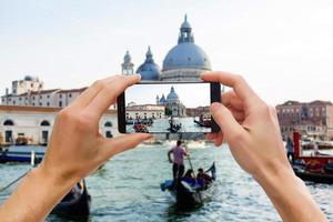 nemen afbeeldingen Aan mobiel slim telefoon in gondel Aan kanaal grande met klassiek oud huis in de achtergrond, Venetië, Italië foto