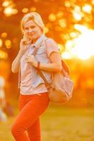 leerling meisje buiten in zomer park glimlachen gelukkig. vrouw college of Universiteit student.kaukasisch jong vrouw model- vervelend school- zak foto