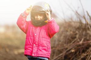 weinig meisje in een motorfiets helm foto