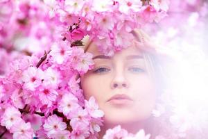verbijsterend jong blond in helder roze bloemen foto