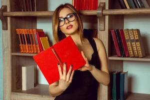 schattig bibliothecaris leest een boek met bril foto