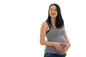 jong vrolijk zwanger moeder glimlachen en op zoek weg geïsoleerd Aan wit achtergrond in studio foto