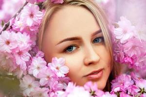 mode portret van seksueel schoonheid blond in bloeiend roze bloemen foto