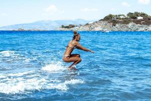 vrolijk meisje duiken in de blauw zee foto