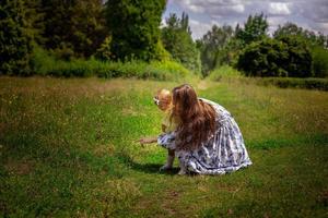 mam points vinger haar weinig dochter naar de groen gras Bij de tuin foto