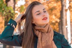 portret van een charmant jong meisje wie verheven hand- naar zijn haar- en Gesloten ogen detailopname foto