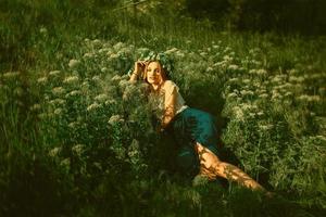 vrouw aan het liegen in de gras met krans Aan hoofd foto