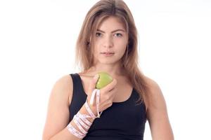 jong atletisch meisje staand zijwaarts Holding een appel in zijn hand- foto