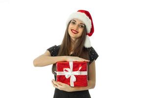 elegant meisje in de kerstman hoed met rood geschenk foto