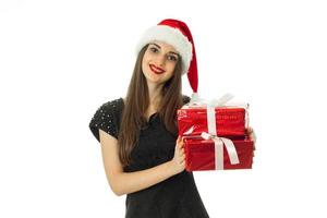jong meisje in de kerstman hoed met rood geschenk foto