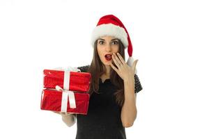 schattig meisje in de kerstman hoed met rood geschenk doos foto