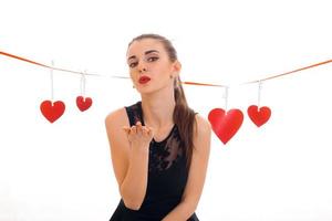 jong lief vrouw met rood lippen voorbereidingen treffen naar vieren valentijnsdag dag met hart symbool in studio geïsoleerd Aan wit achtergrond foto