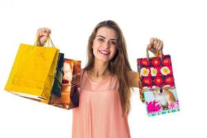 jong glimlachen meisje uitgerekt uit haar Rechtsaf hand- met groot pakketjes geschenk dozen geïsoleerd Aan wit achtergrond foto