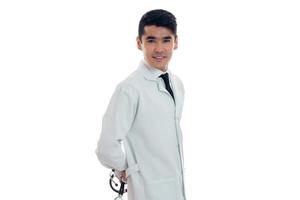 jong mannetje dokter in wit uniform met stethoscoop op zoek Bij de camera geïsoleerd geïsoleerd in studio foto