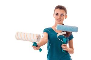 jong vrolijk brunette vrouw bouwer in uniform met verf rol in handen maken renovaties geïsoleerd Aan wit achtergrond foto