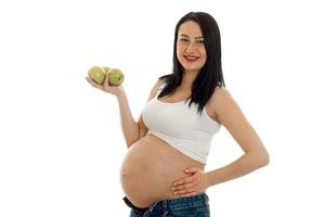 vrolijk zwanger brunette meisje in groot buik poseren geïsoleerd Aan wit achtergrond foto