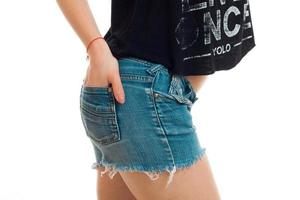 vrouwen billen in denim shorts en een detailopname van een hand- in zak- foto