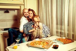 horizontaal portret van pret drie mensen Bij een partij met pizza en alcohol foto