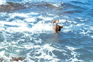 schattig meisje zwemt in de zee foto