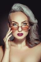 portret van schattig vrouw in elegant zonnebril met grijs haar- kleur en mooi hoor bedenken foto