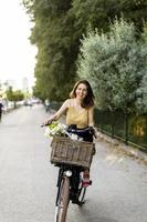 vrouw met bloemen in de mand van elektrisch fiets foto