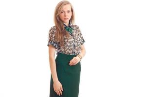 jong sexy blond staat in blouse en groen rok en looks in een camera foto