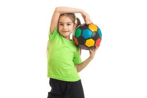 schattig weinig meisje met een voetbal bal in de handen foto