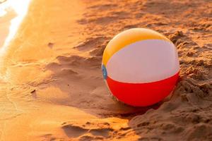 strand bal Aan de kust Bij zonsondergang foto