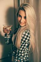 verticaal portret van sexy blond vrouw met glas van martini Bij de partij foto