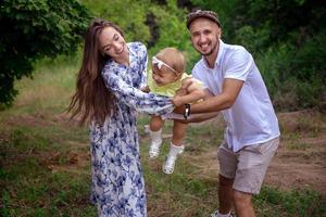 gelukkig ouders Toneelstukken met weinig dochter en lachend Bij de groen tuin foto