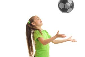 weinig meisje gooit de bal omhoog geïsoleerd Aan wit achtergrond foto