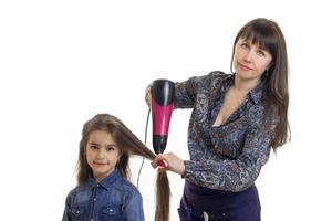 jong vrouw droogt haar- schattig weinig meisje geïsoleerd Aan wit achtergrond foto