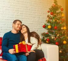 Kerstmis vooravond. gelukkig jong familie met presenteert voor nieuw jaar foto